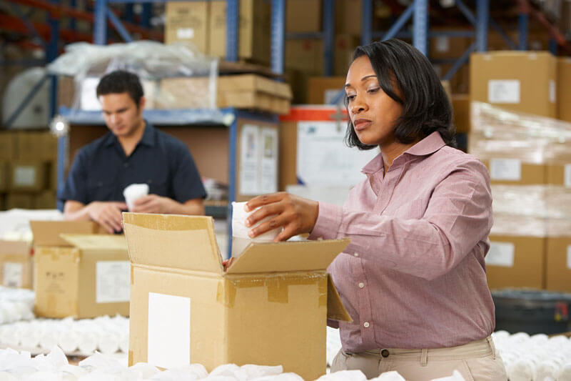 Two packers placing product in boxes